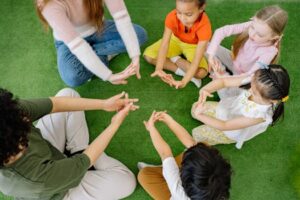 A group of diverse children sit in a circle, engaging in play and learning activities.
